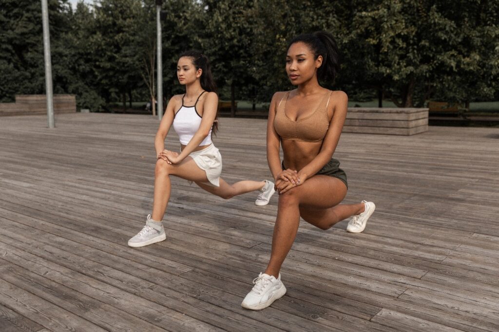 Two girls doing lunges, one of the best training exercises for hiking